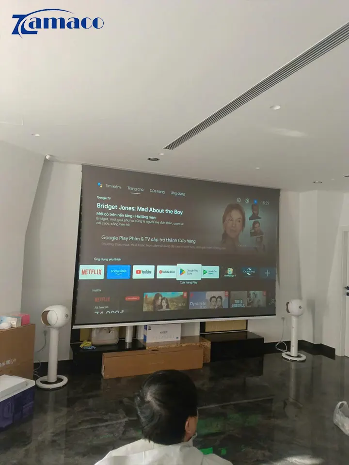 Màn chiếu ALR Vividstorm đang hoạt động cùng máy chiếu Epson LS800B, hiển thị giao diện Google TV sắc nét